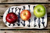 Three apples on a porcelain plate